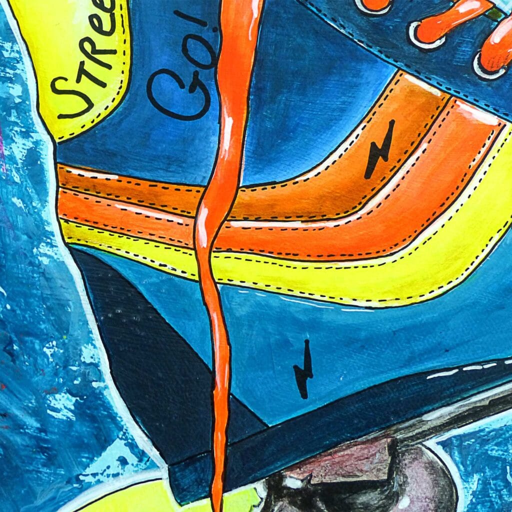 Détail de la chaussure bleue, orange et jaune du patin, où se lisent les mots « Street » et « Go »