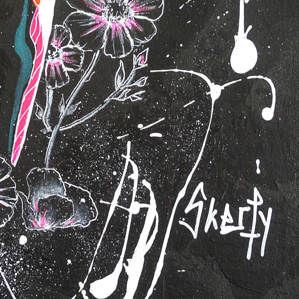 Détail de la signature « Skerfy » peinte en blanc sur le fond noir, parmi les coulures et les fleurs au trait