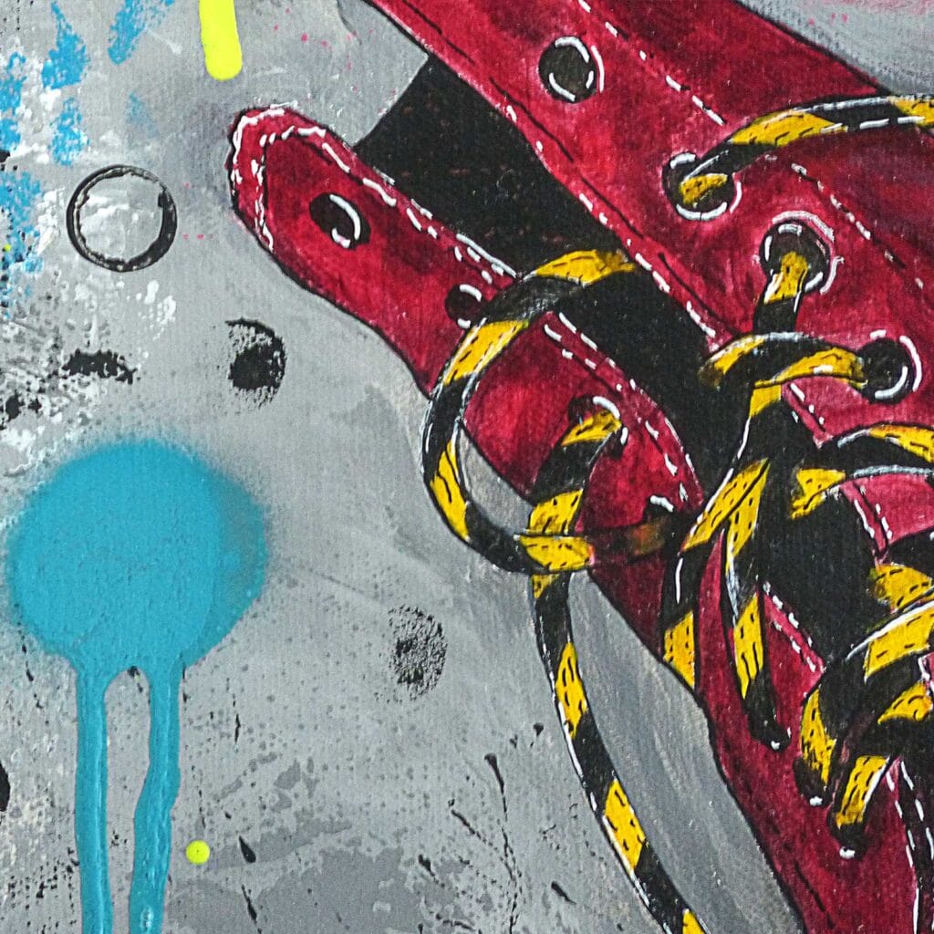 Détail du haut de la bottine bordeaux, lacets jaunes et noirs, fond gris et bombe de peinture turquoise