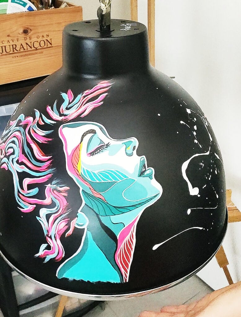 Premier lustre verso pour l'exposition çafaitdeslustres, un visage féminin coloré abstrait, cheveux au vent peint à l'acrylique sur fond noir.