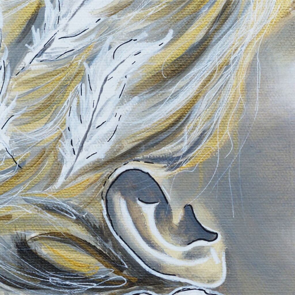 Détail de l'oreille beige marron avec des traits noirs, une partie de la chevelure qui présente des nuances de doré et des lignes blanches fines. Deux plumes blanches dans les cheveux, avec quelques traits noirs.